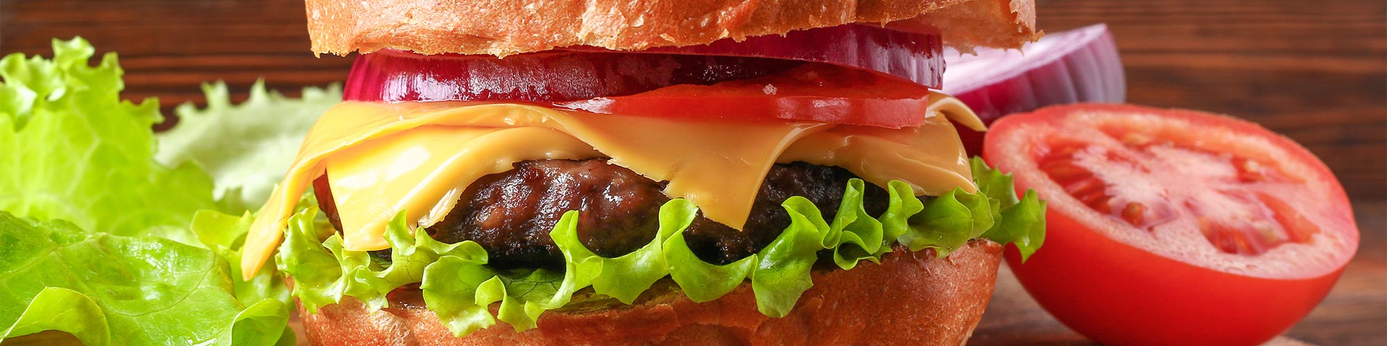 Delicious cheese burger with lettuce, tomato, and onion.